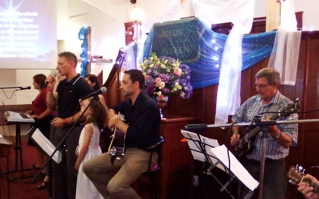 ‘n Deel van die orkes en sangers tydens Stanford se gesamentlike Kerssangdiens, met ds Neil Ollewagen, self ‘n knap sanger, met die mikrofoon in sy hand